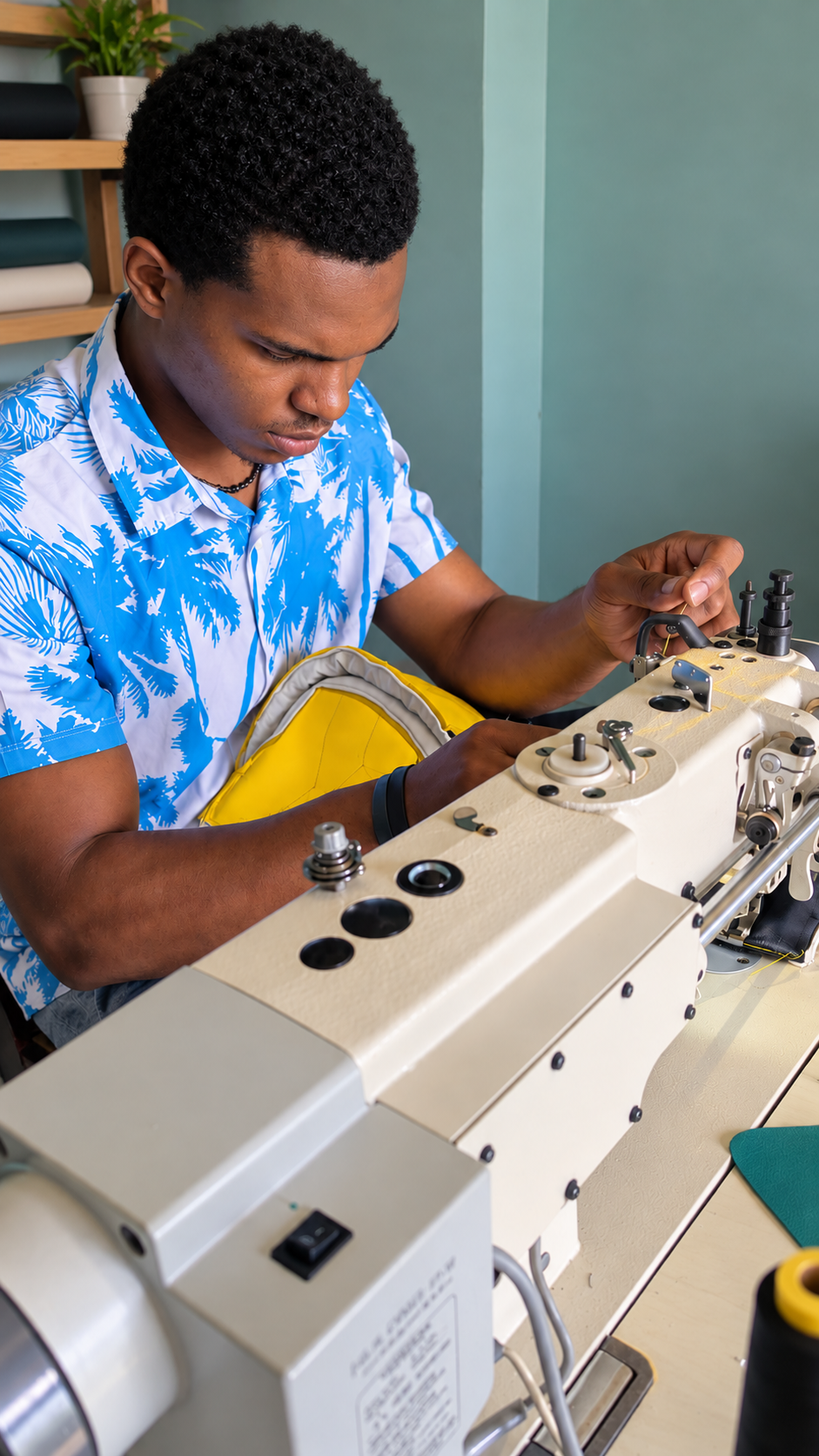 Thaddeus Clarke, Anchor Stitch's owner, focused at an industrial sewing machine in the workshop